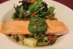 Orange and maple roasted salmon fillet on a warm potato, bean and bacon salad with a cashew nut pesto and salad greens